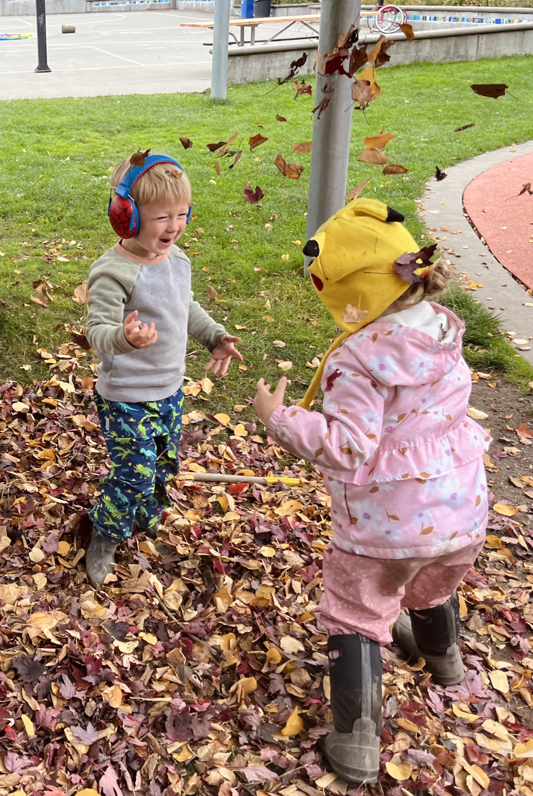 two children playing with leaves